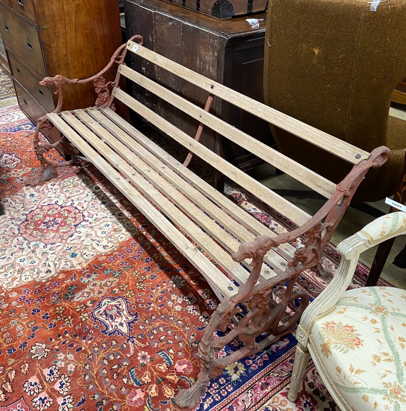 A Coalbrookdale style cast iron garden bench with dog's head and serpent terminals, length 158cm